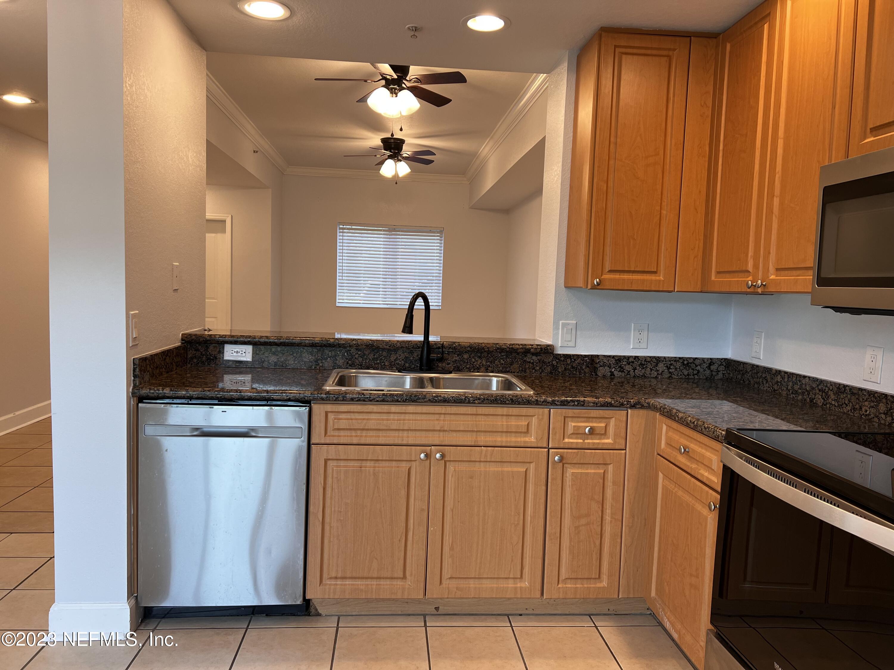 9745 Touchton Road, Unit 1702 Jacksonville, FL 32246 - Photo 12 of 62 a kitchen with stainless steel appliances granite countertop a sink and cabinets