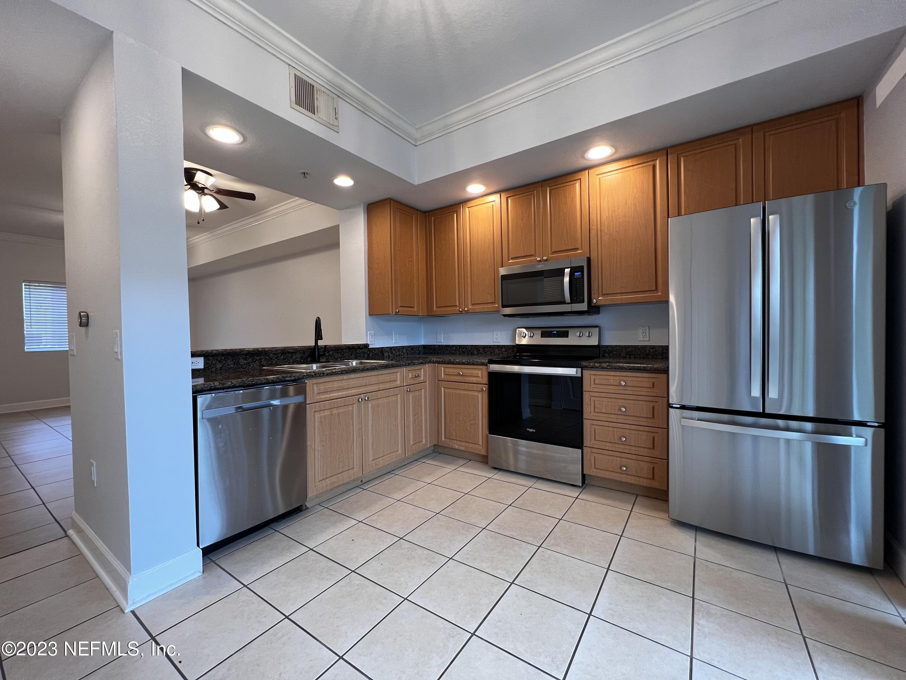 9745 Touchton Road, Unit 1702 Jacksonville, FL 32246 - Photo 13 of 62 a kitchen with granite countertop stainless steel appliances and white cabinets