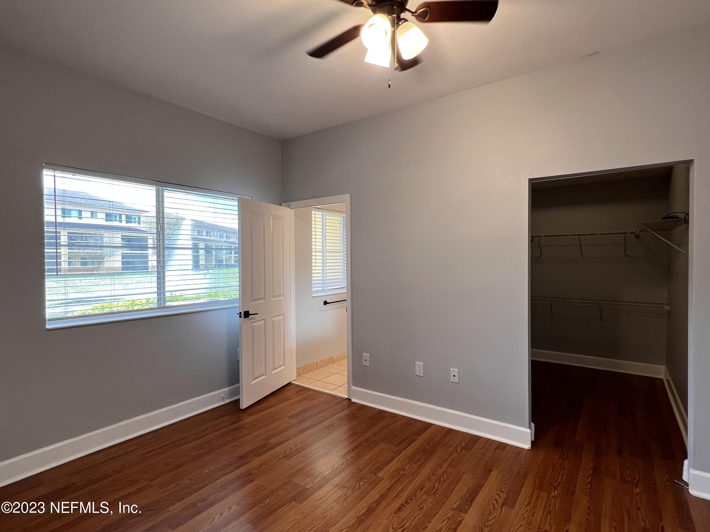 9745 Touchton Road, Unit 1702 Jacksonville, FL 32246 - Photo 28 of 62 an empty room with wooden floor fan and windows