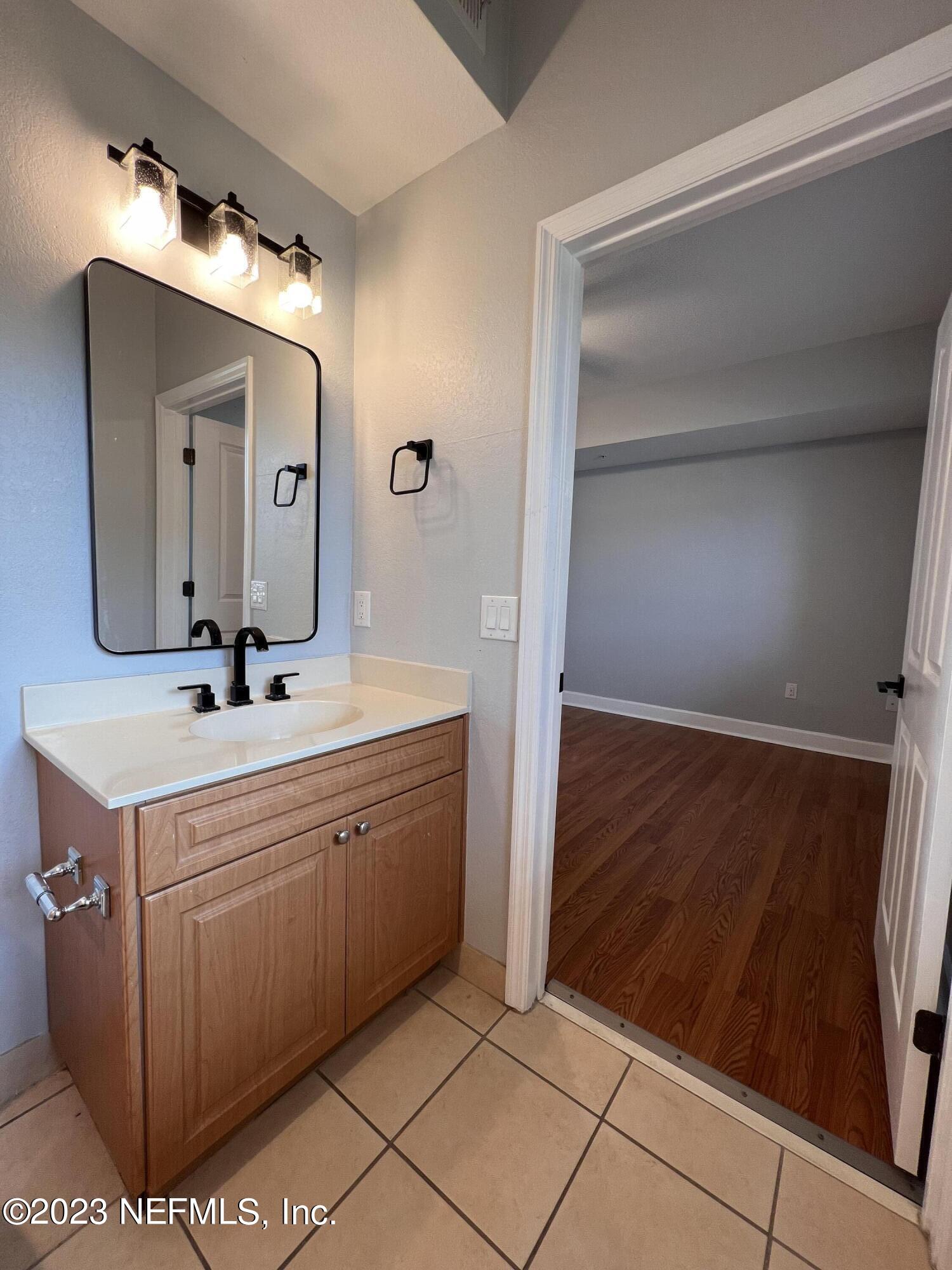 9745 Touchton Road, Unit 1702 Jacksonville, FL 32246 - Photo 30 of 62 a bathroom with a sink a mirror and a vanity