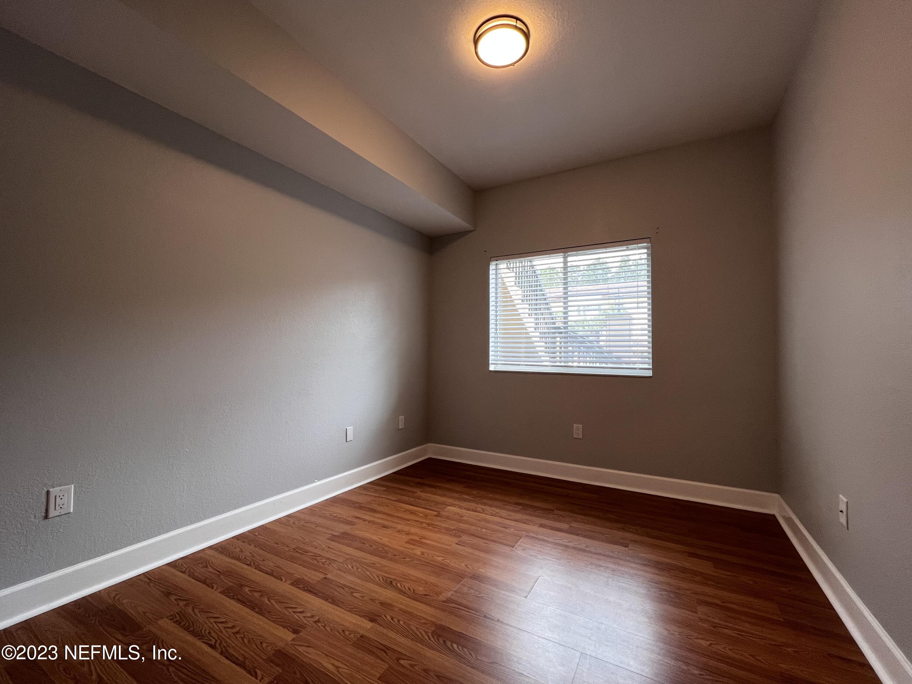 9745 Touchton Road, Unit 1702 Jacksonville, FL 32246 - Photo 33 of 62 an empty room with wooden floor and windows