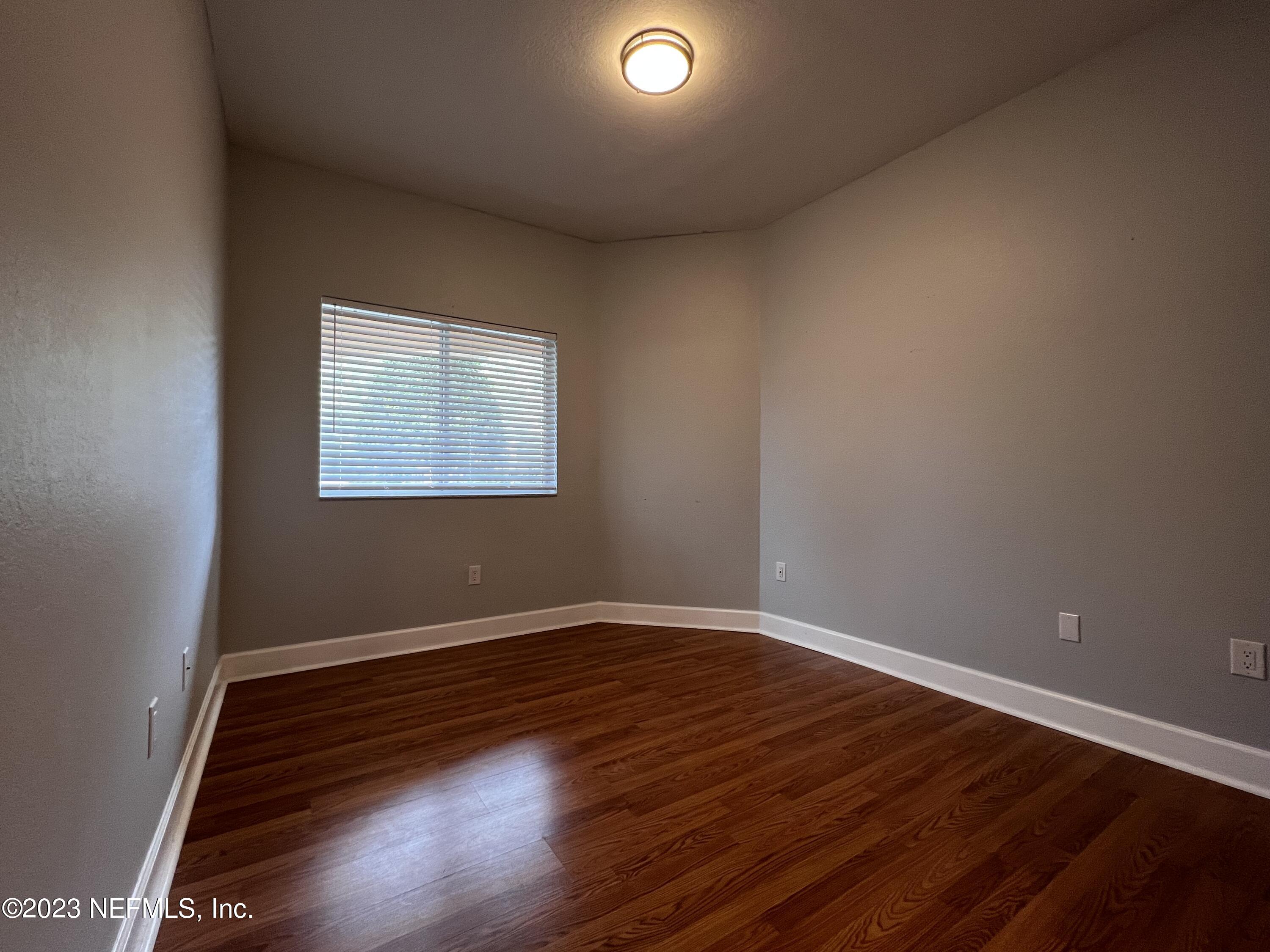 9745 Touchton Road, Unit 1702 Jacksonville, FL 32246 - Photo 36 of 62 an empty room with wooden floor and windows