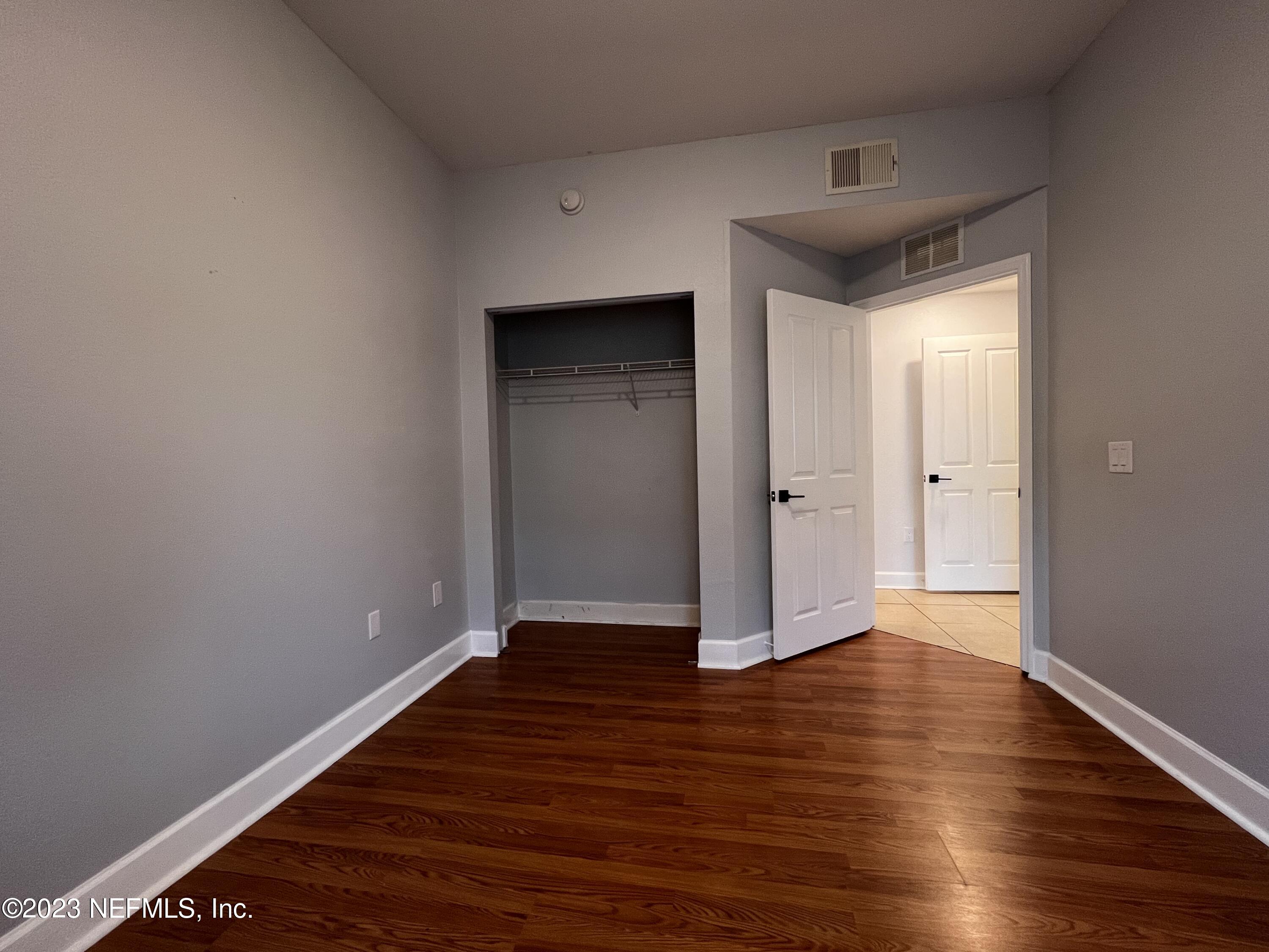 9745 Touchton Road, Unit 1702 Jacksonville, FL 32246 - Photo 37 of 62 a view of an empty room with wooden floor and a window