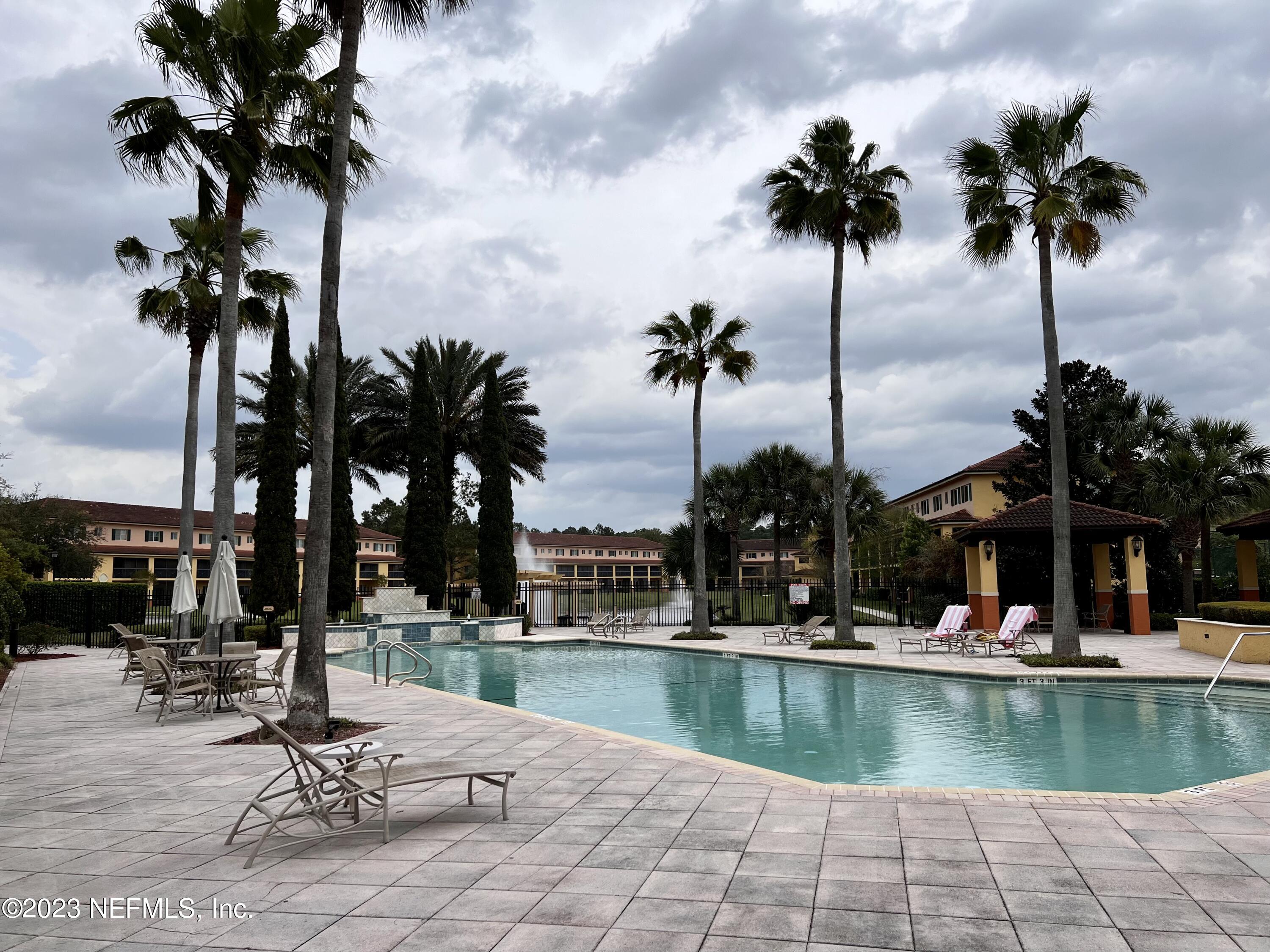 9745 Touchton Road, Unit 1702 Jacksonville, FL 32246 - Photo 49 of 62 a view of a swimming pool with a table and chairs