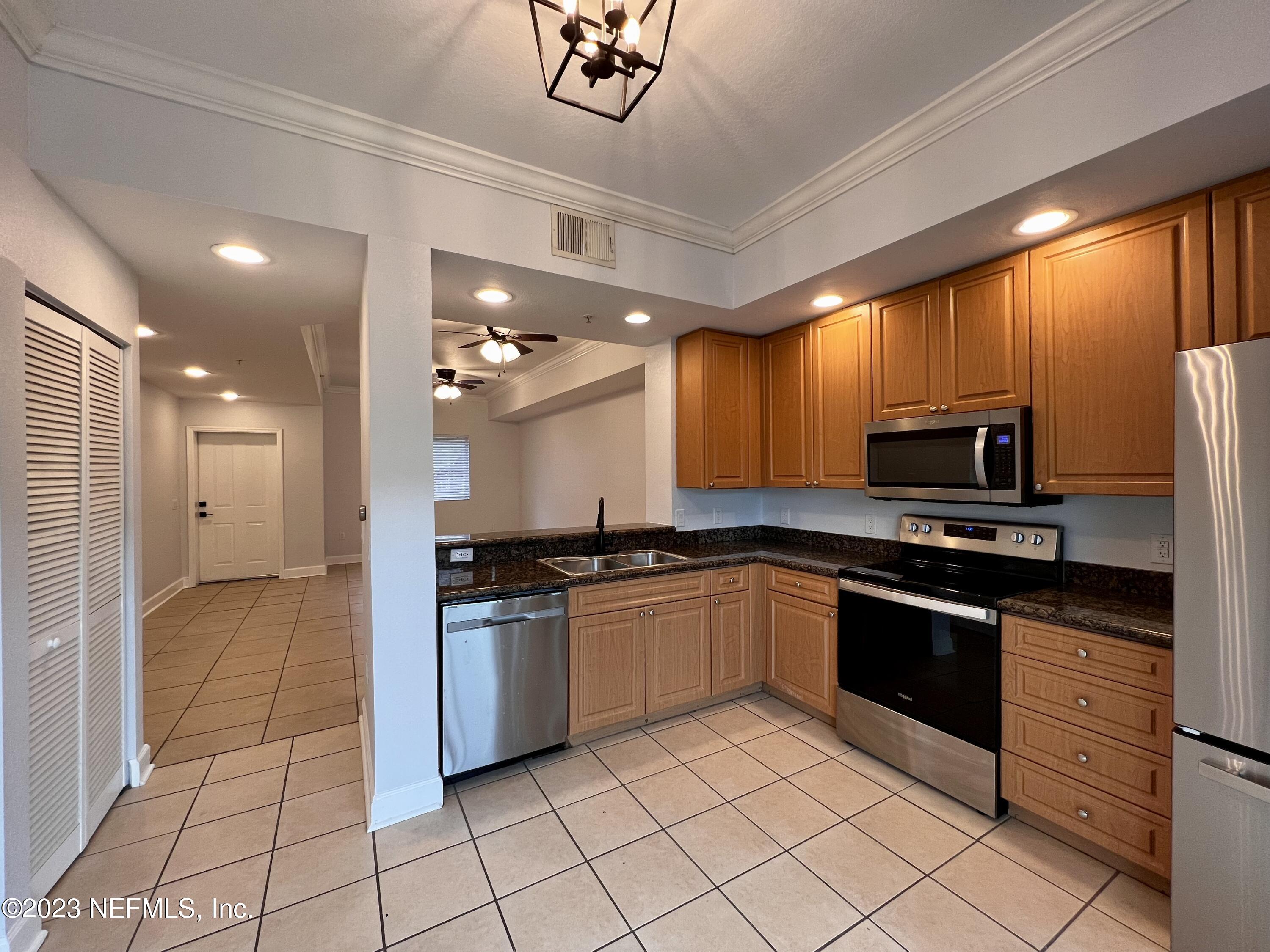 9745 Touchton Road, Unit 1702 Jacksonville, FL 32246 - Photo 10 of 62 a kitchen with stainless steel appliances granite countertop a stove sink and cabinets