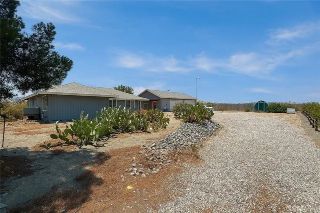 a view of a house with a yard and potted plants
