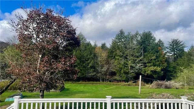 a view of a house with a yard deck and a slide