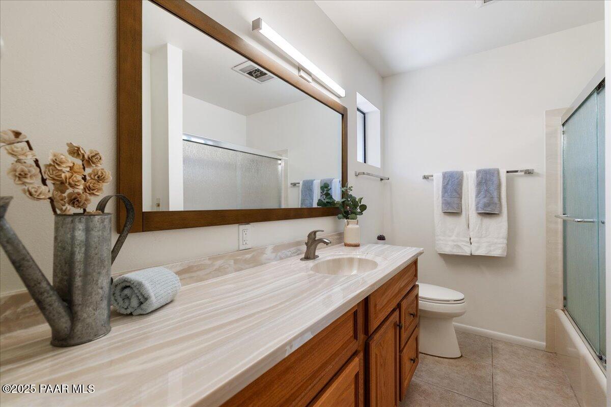 1271 Tanglewood Road Prescott, AZ 86303 - Photo 11 of 18 a bathroom with a granite countertop sink a toilet and a mirror