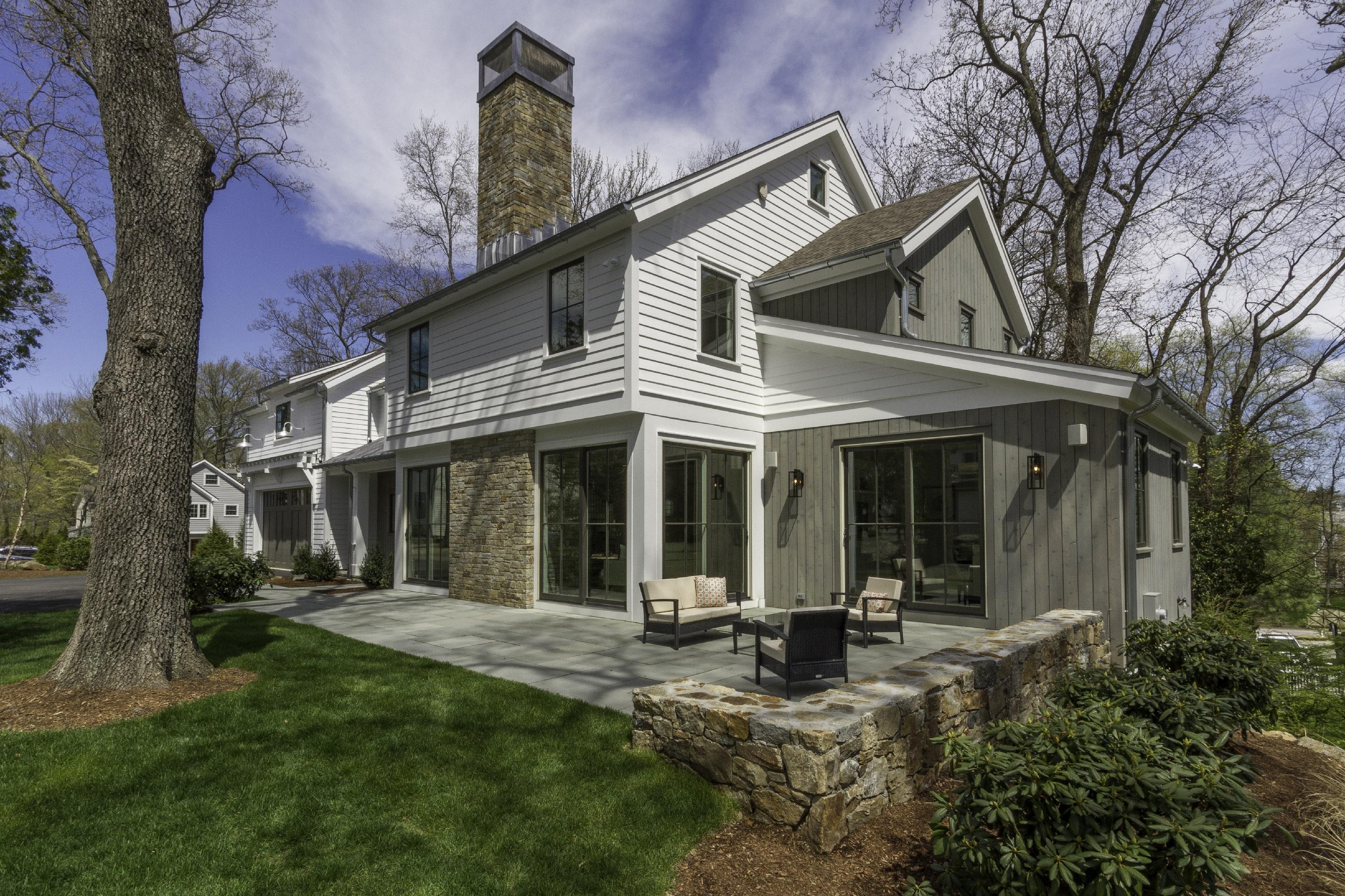 a view of a white house with a small yard and plants
