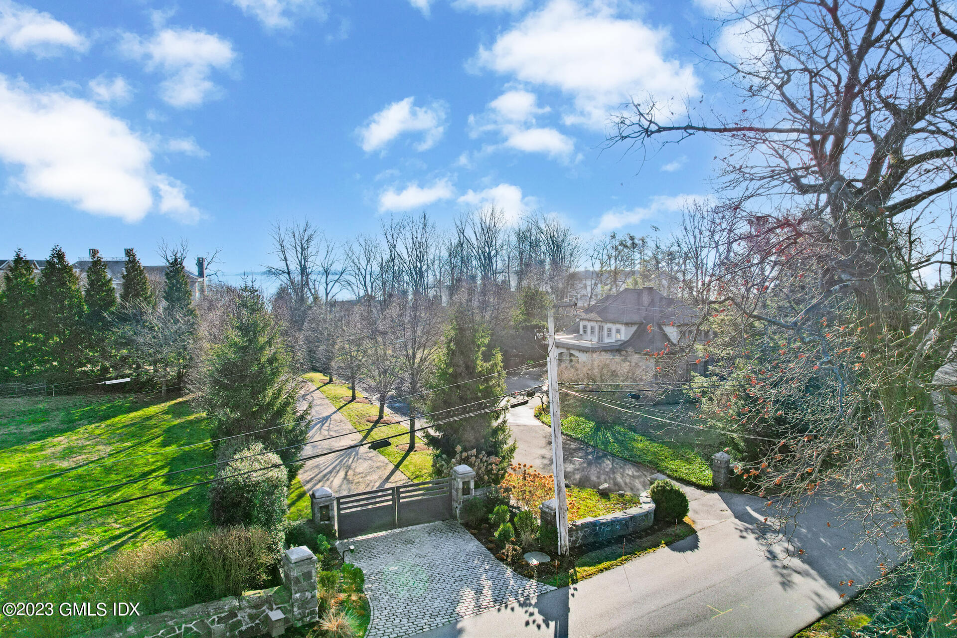 180 Byram Shore Road Greenwich, CT 06830 - Photo 19 of 29 a view of a garden with a bench in front of the house