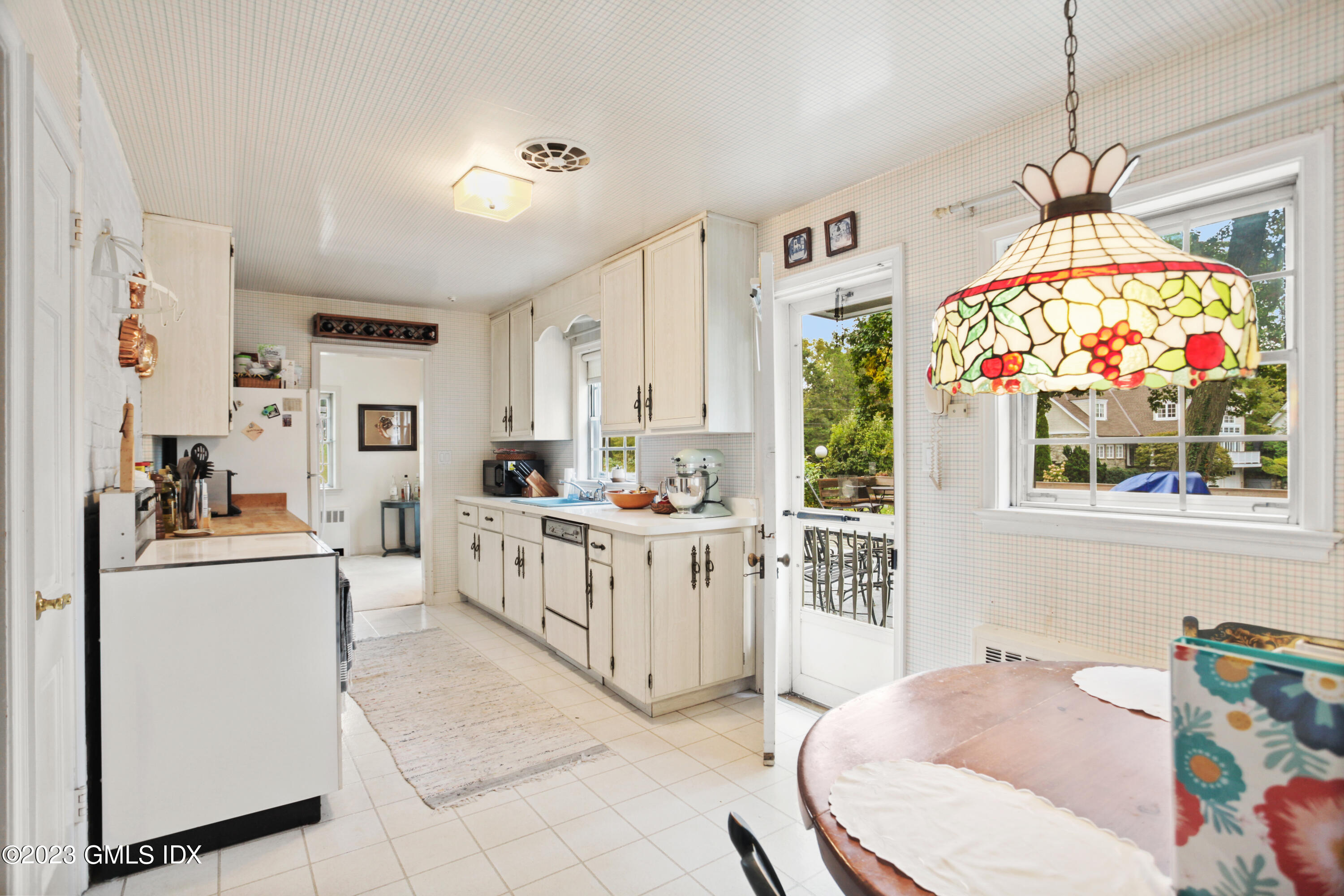 180 Byram Shore Road Greenwich, CT 06830 - Photo 8 of 29 a kitchen with stainless steel appliances kitchen island granite countertop a stove a sink a refrigerator and a dining table with granite countertop chairs