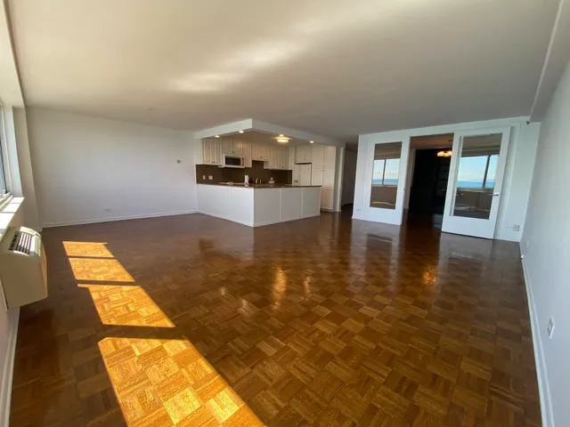 an empty room with kitchen view