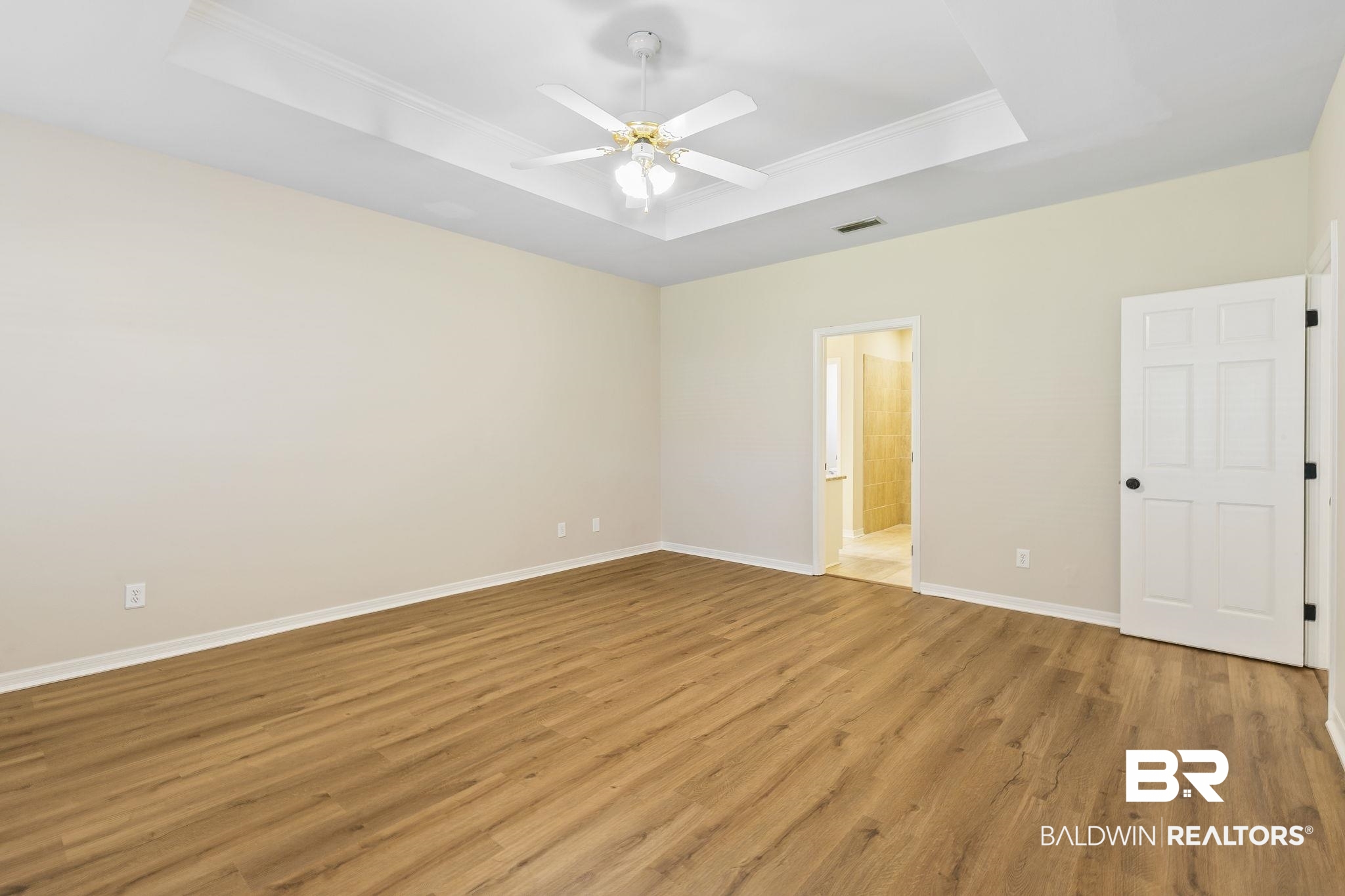 9631 Bay Meadows Avenue Fairhope, AL 36532 - Photo 18 of 49 Unfurnished bedroom with ceiling fan, ensuite bath, light hardwood / wood-style flooring, and a tray ceiling