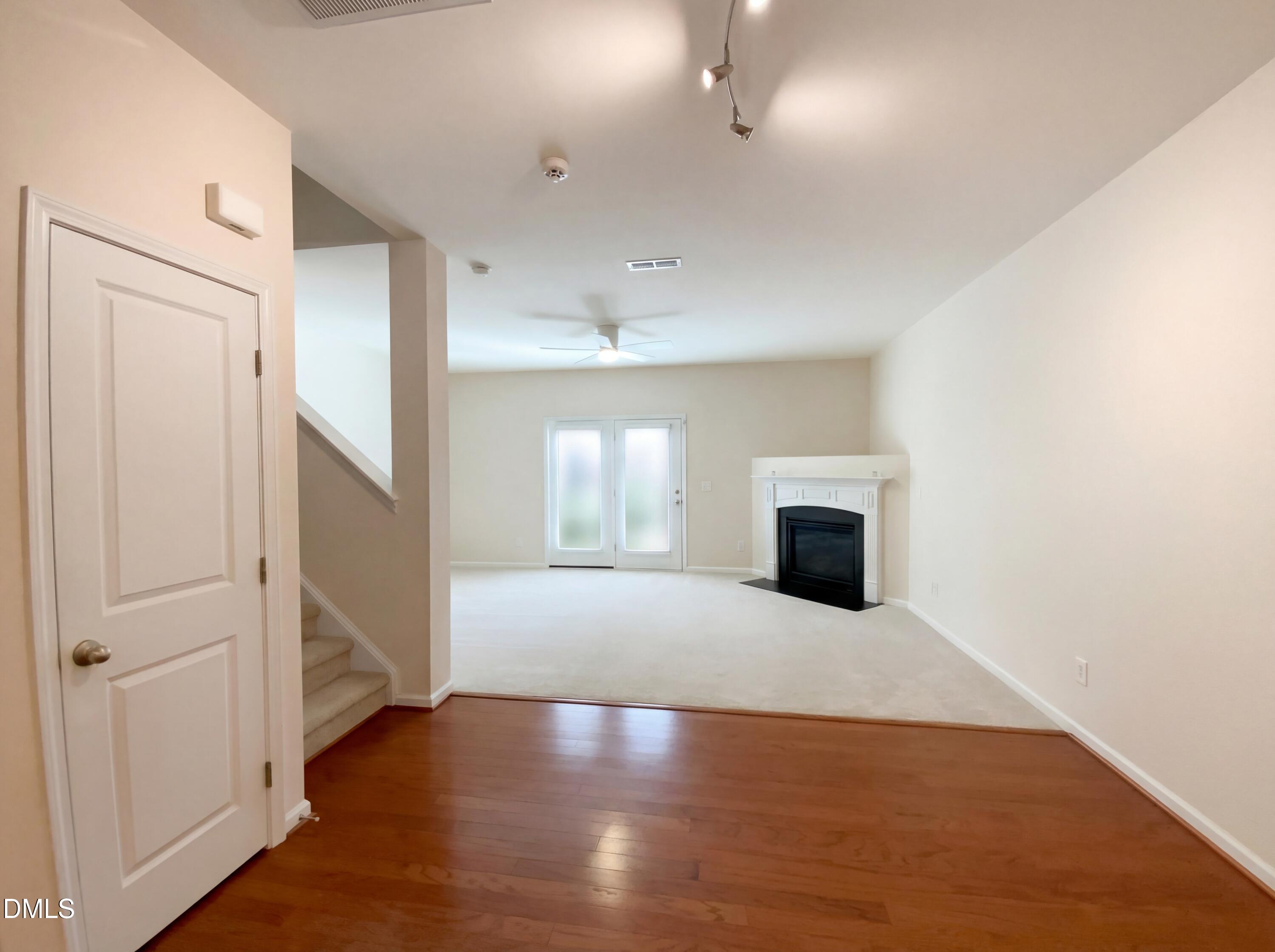 1661 Holly Grove Way Durham, NC 27713 - Photo 9 of 19 an empty room with wooden floor fireplace and windows