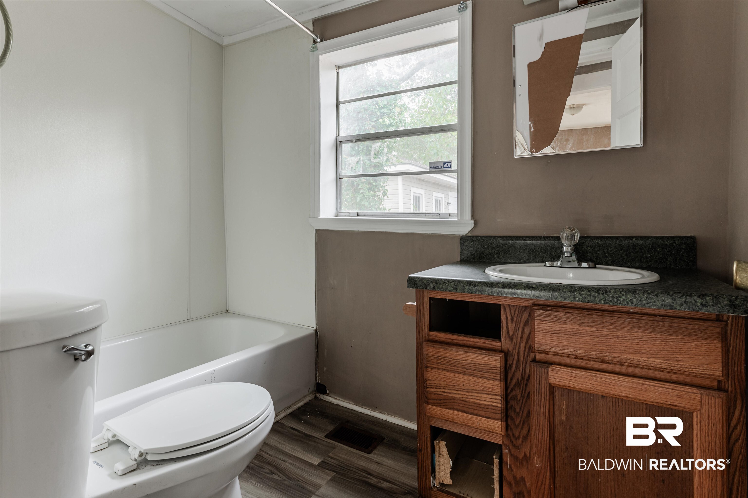 600 Mohawk Street Mobile, AL 36606 - Photo 19 of 20 Full bathroom with vanity, toilet, shower combination, and wood-type flooring