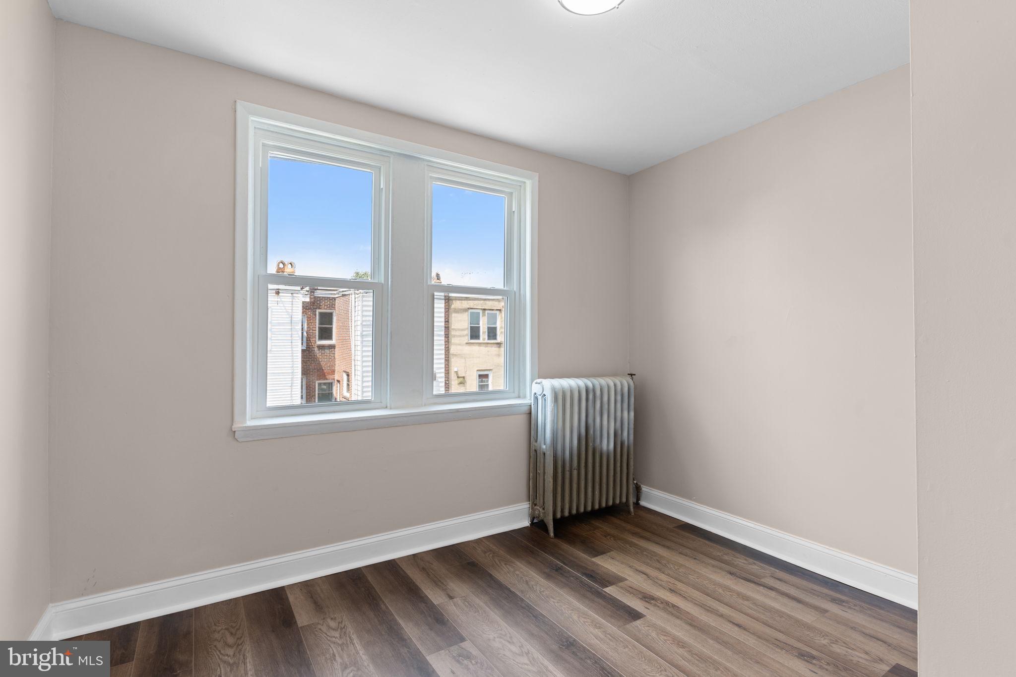7122 Gillespie Street Philadelphia, PA 19135 - Photo 16 of 24 a view of an empty room with wooden floor and a window
