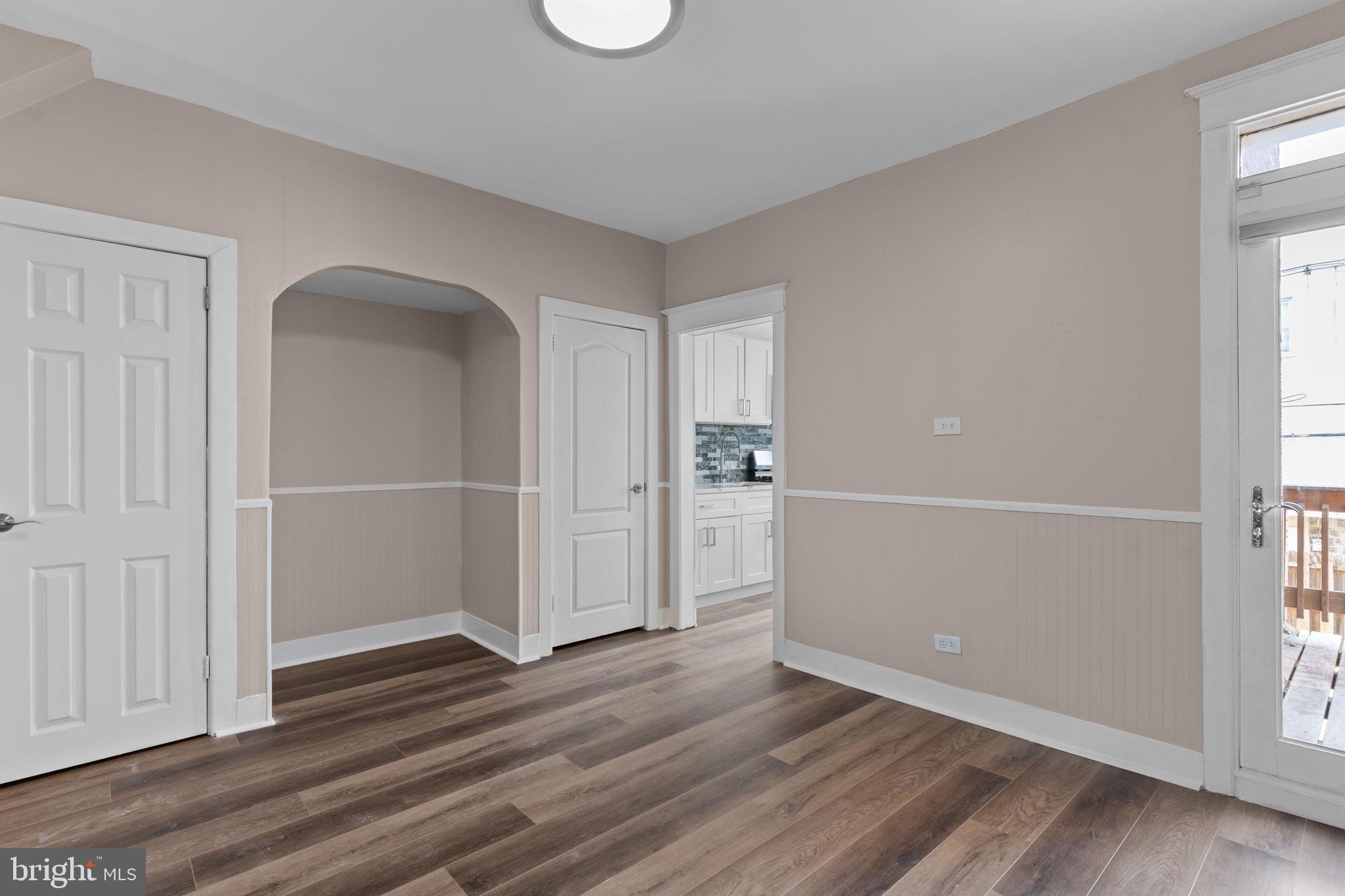 7122 Gillespie Street Philadelphia, PA 19135 - Photo 6 of 24 an empty room with wooden floor cabinet and windows