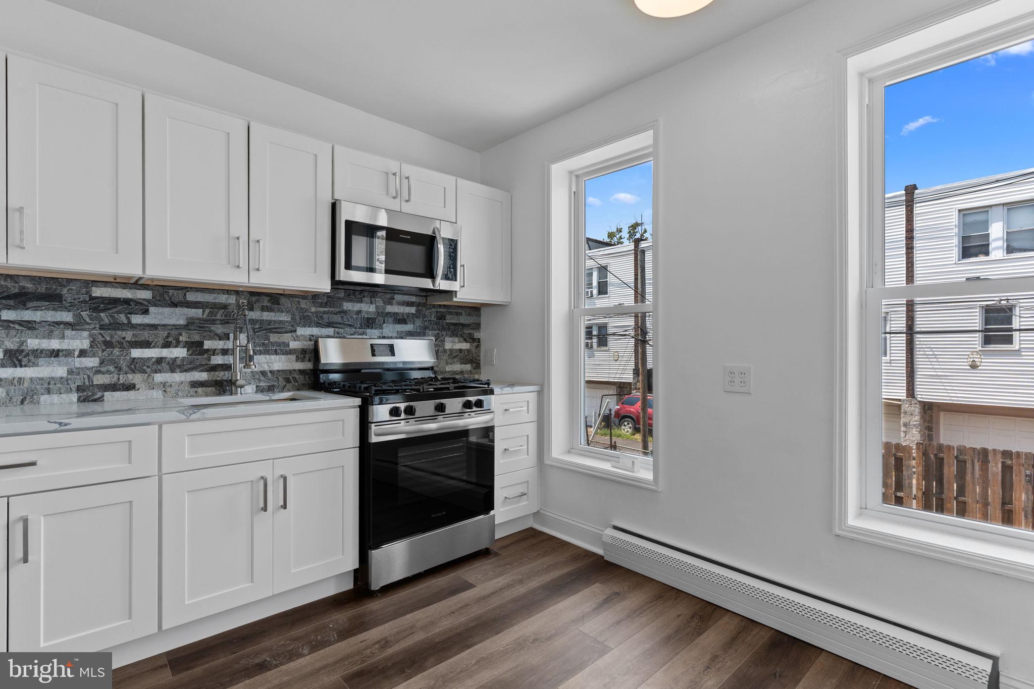 7122 Gillespie Street Philadelphia, PA 19135 - Photo 7 of 24 a kitchen with stainless steel appliances granite countertop a stove and a sink