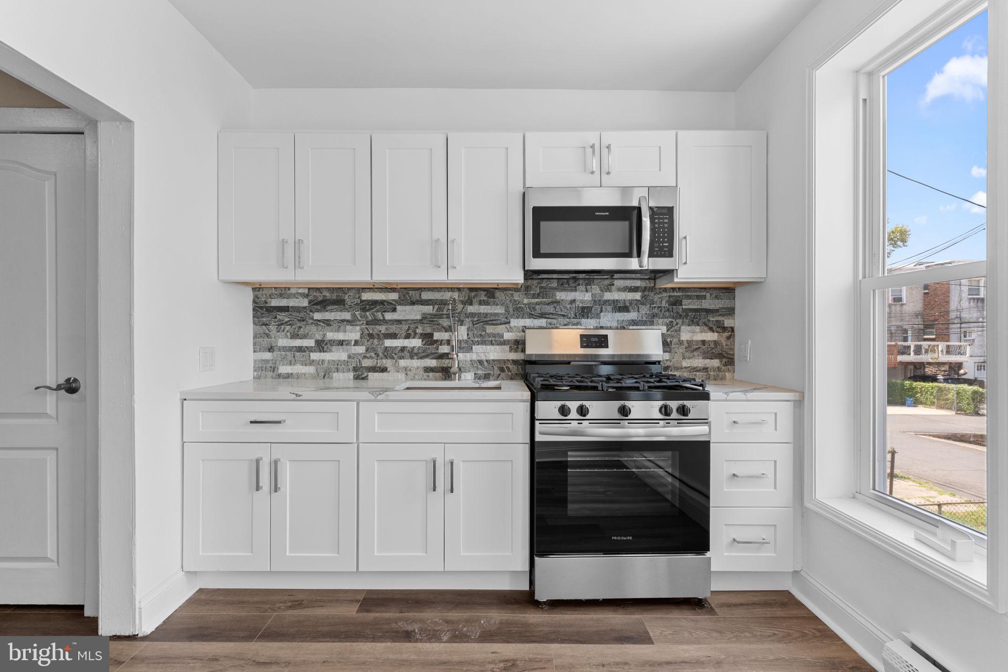 7122 Gillespie Street Philadelphia, PA 19135 - Photo 10 of 24 a kitchen with white cabinets and stainless steel appliances