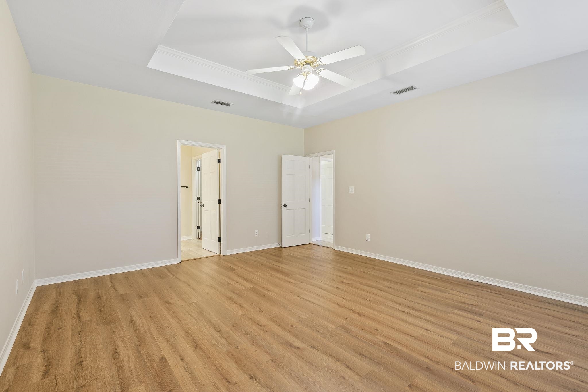 9631 Bay Meadows Avenue Fairhope, AL 36532 - Photo 19 of 49 Primary bedroom featuring a tray ceiling, ceiling fan, and light hardwood / wood-style floors.