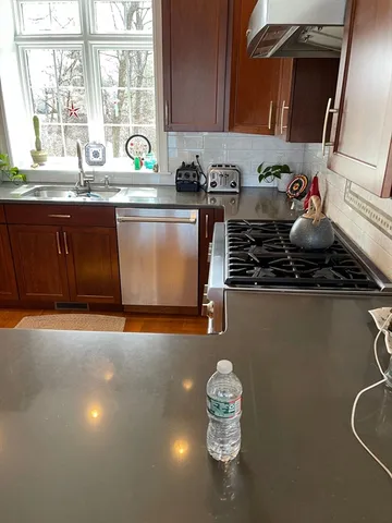 a kitchen with stainless steel appliances a sink a stove and a window