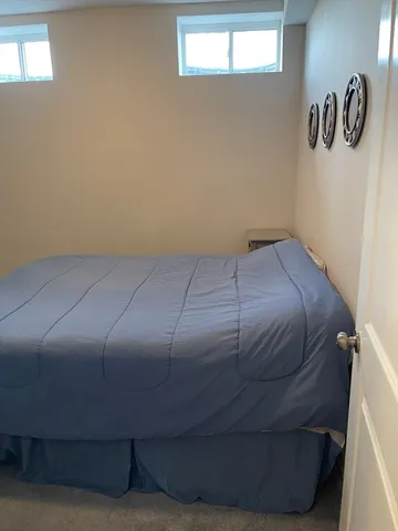 a bed sitting in a bedroom next to a window