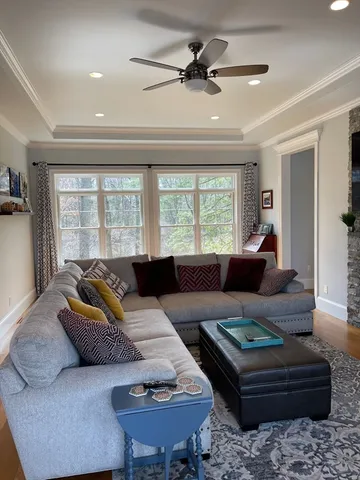 a living room with furniture ceiling fan and a window