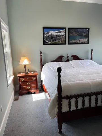 a bed sitting in a bedroom next to a lamp