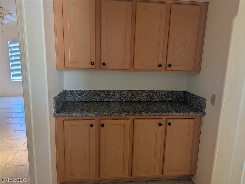 9433 Quail Ridge Drive Las Vegas, NV 89134 - Photo 17 of 23 Functional cabinetry provides storage, accented by granite counters and tiled flooring.