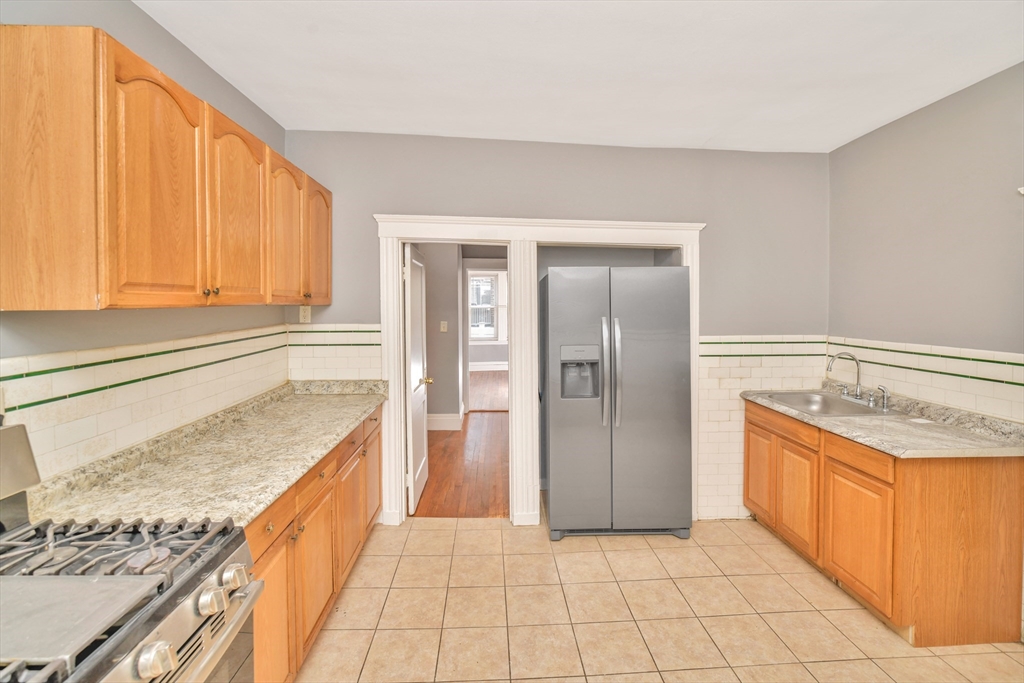 146 Homestead Street Boston, MA 02121 - Photo 11 of 40 a kitchen with stainless steel appliances granite countertop a sink and a stove