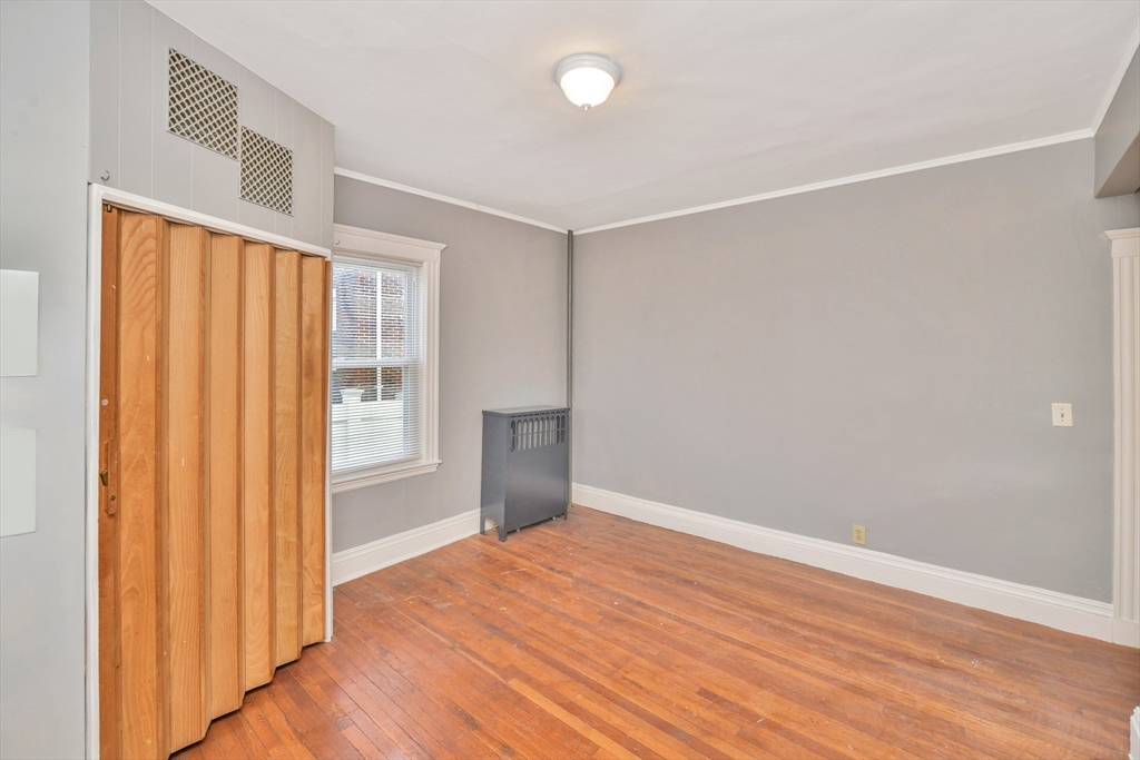146 Homestead Street Boston, MA 02121 - Photo 16 of 40 an empty room with wooden floor and windows