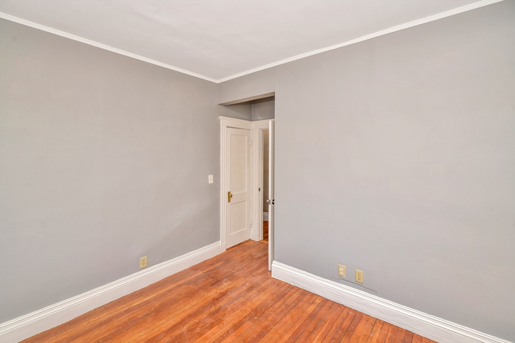 146 Homestead Street Boston, MA 02121 - Photo 17 of 40 a view of an empty room with wooden floor