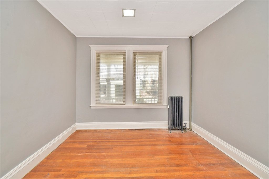 146 Homestead Street Boston, MA 02121 - Photo 18 of 40 a view of an empty room with wooden floor and a window