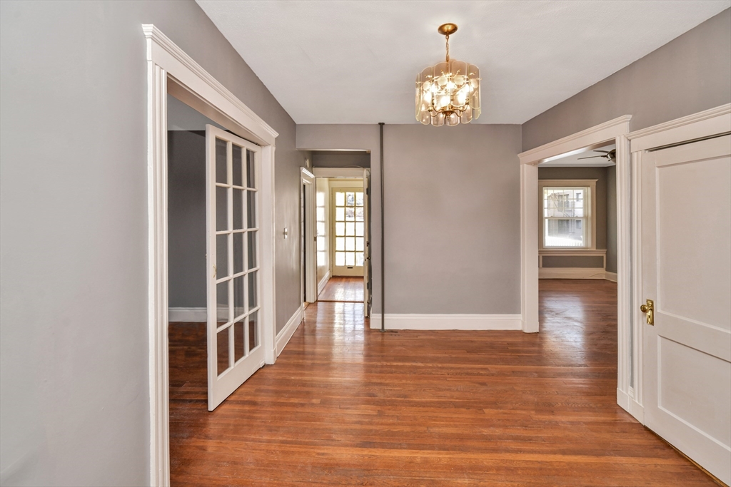 146 Homestead Street Boston, MA 02121 - Photo 23 of 40 a hallway with wooden floor and chandelier