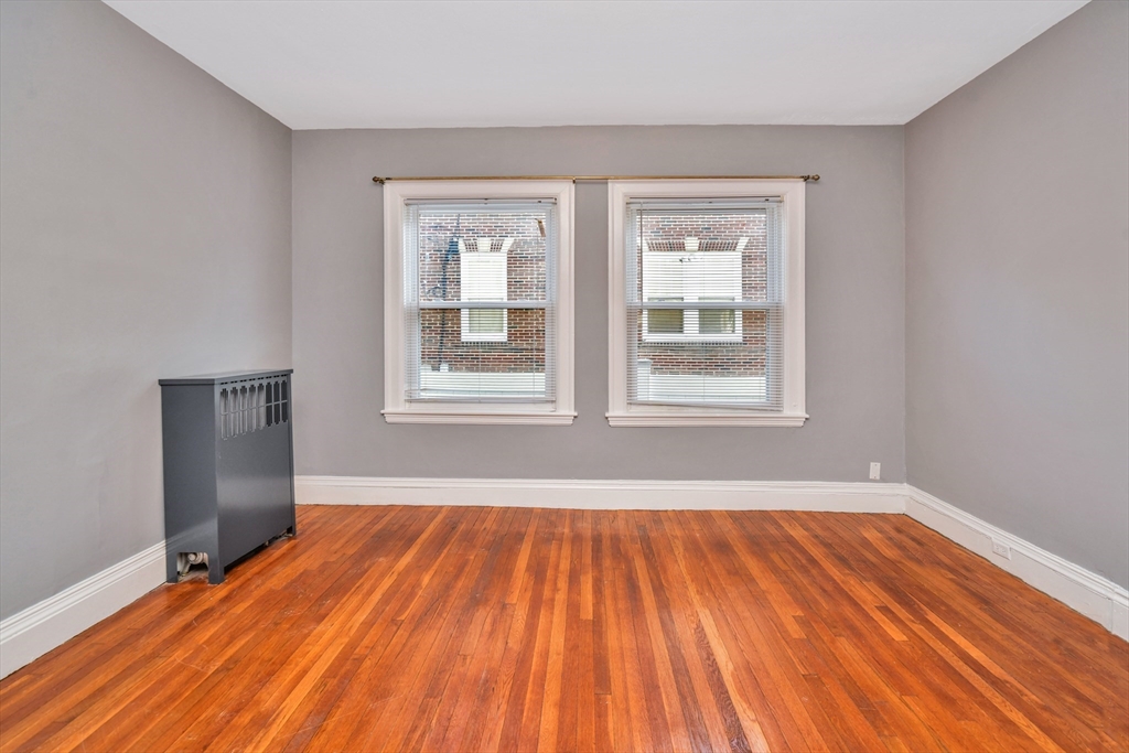 146 Homestead Street Boston, MA 02121 - Photo 35 of 40 a view of an empty room with wooden floor and a window