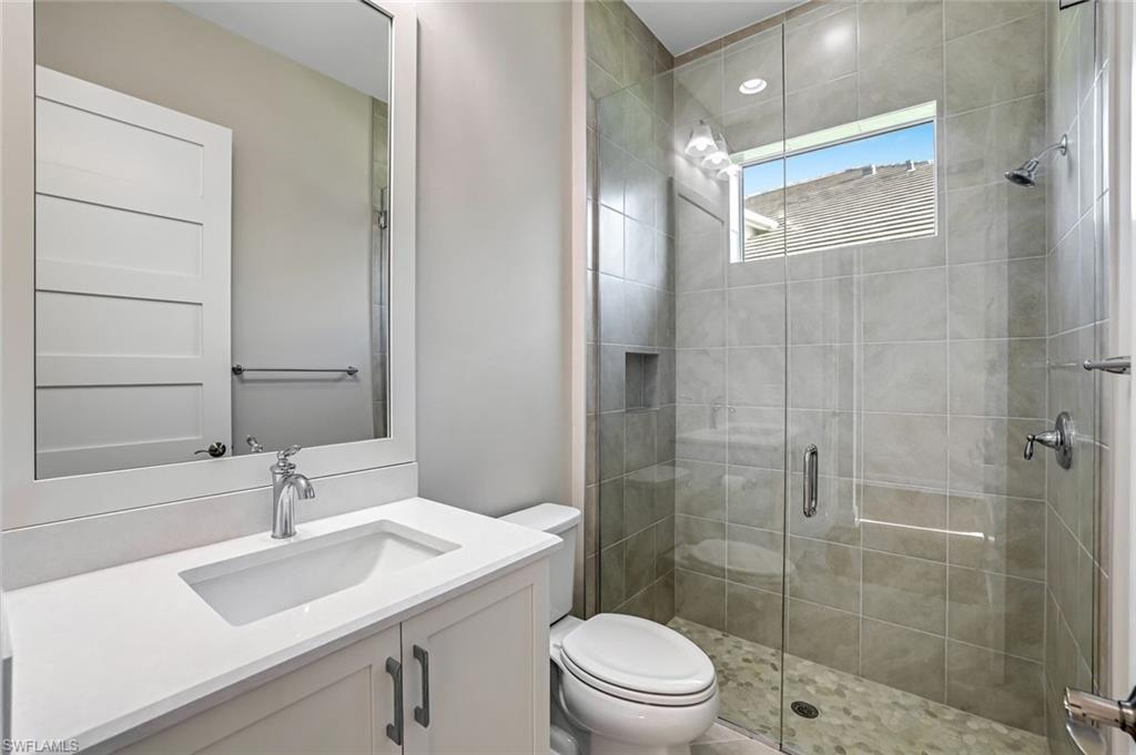 8921 Yucatan Court Naples, FL 34113 - Photo 11 of 20 a bathroom with a sink toilet a mirror and shower