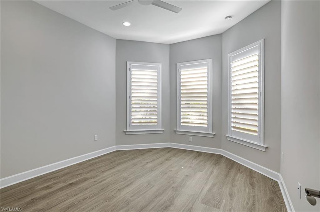8921 Yucatan Court Naples, FL 34113 - Photo 5 of 20 an empty room with wooden floor and windows