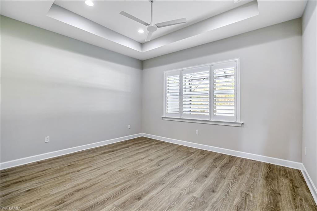 8921 Yucatan Court Naples, FL 34113 - Photo 7 of 20 wooden floor in an empty room with a window
