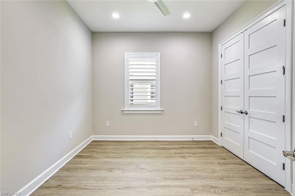 8921 Yucatan Court Naples, FL 34113 - Photo 10 of 20 a view of an empty room with wooden floor and a window