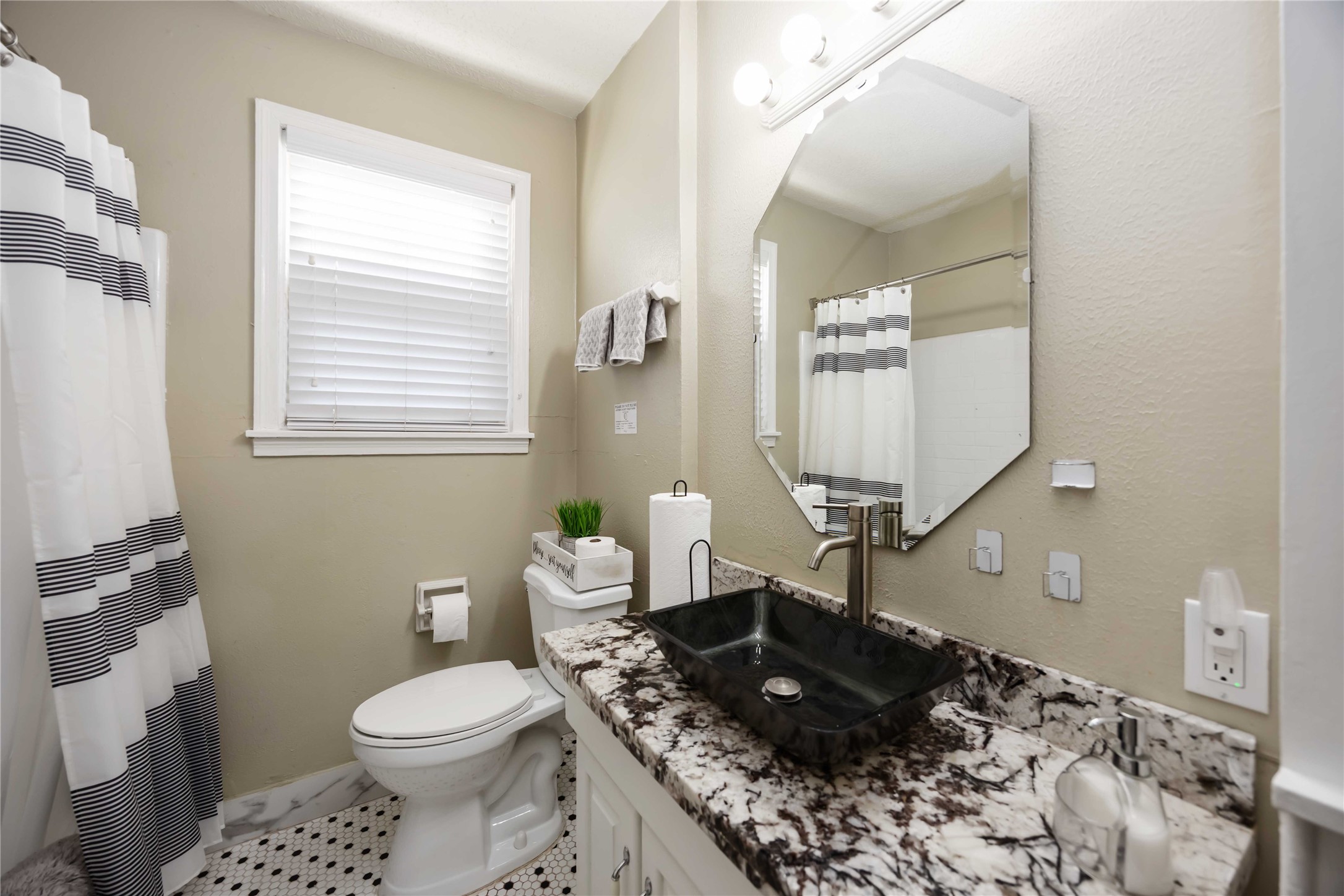 2104 Winbern Street Houston, TX 77004 - Photo 16 of 24 a bathroom with a granite countertop toilet a sink and a mirror
