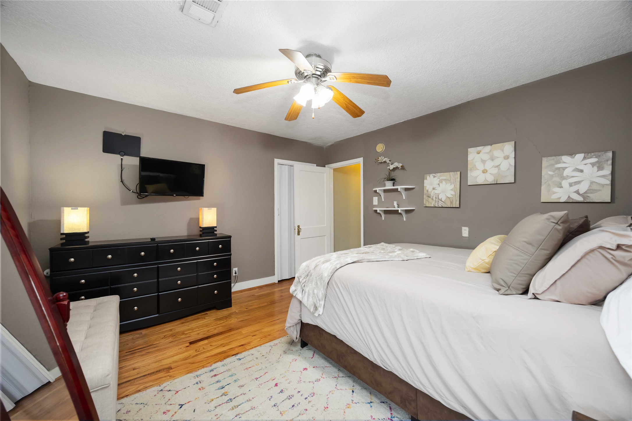 2104 Winbern Street Houston, TX 77004 - Photo 19 of 24 a bedroom with a bed and a flat tv screen on dresser