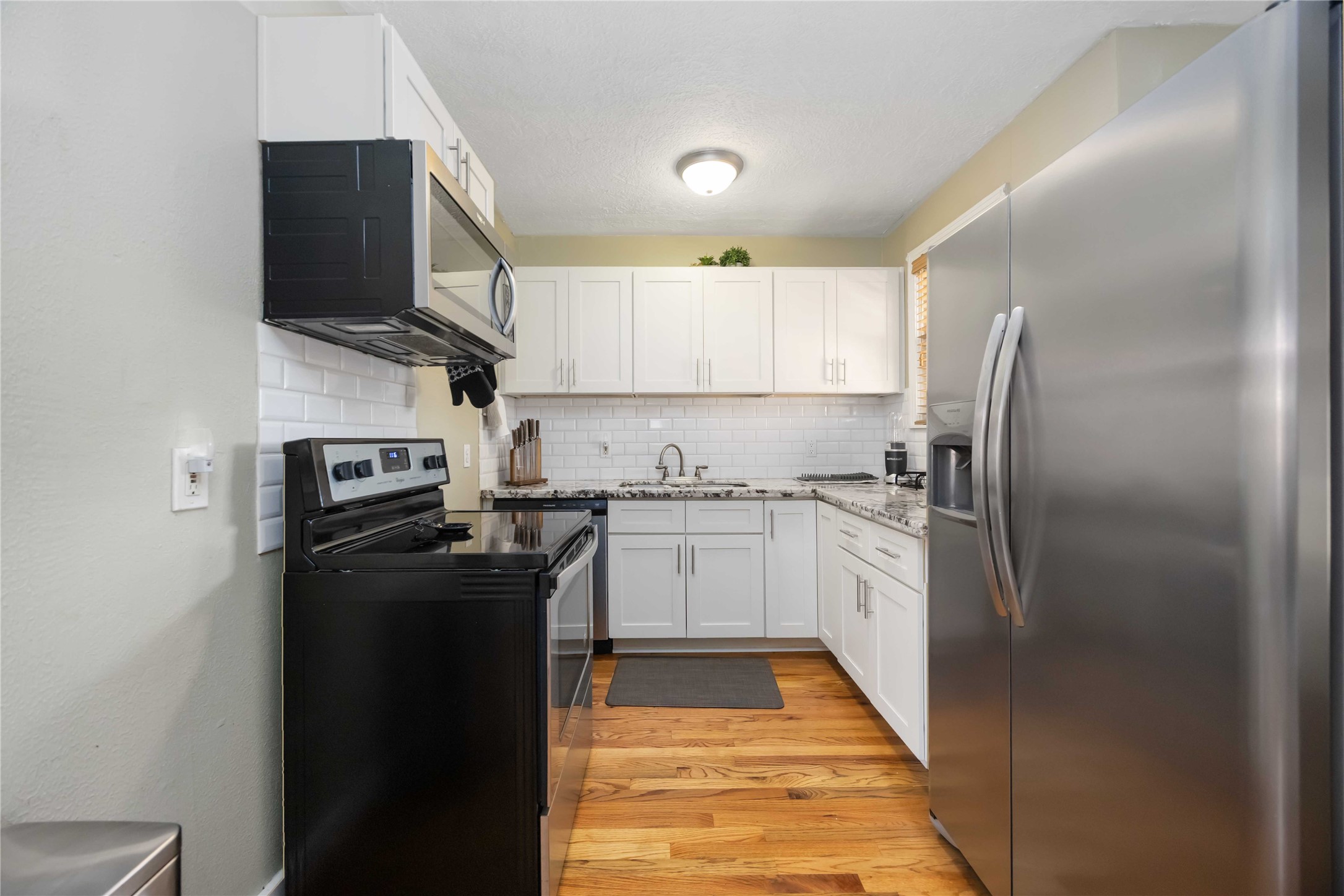 2104 Winbern Street Houston, TX 77004 - Photo 21 of 24 a kitchen with stainless steel appliances granite countertop a refrigerator a stove top oven a sink and dishwasher