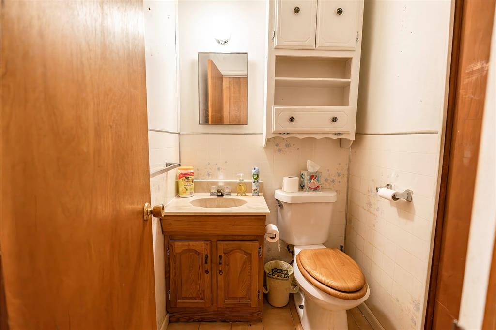 205 Bonham Street Nocona, TX 76255 - Photo 15 of 21 a bathroom with a sink a toilet and shower curtain