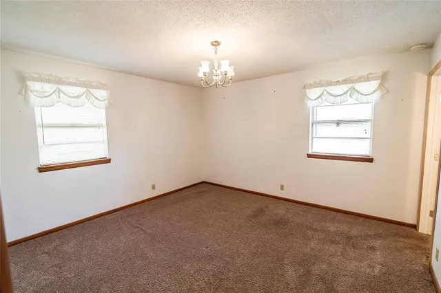 an empty room with windows and chandelier