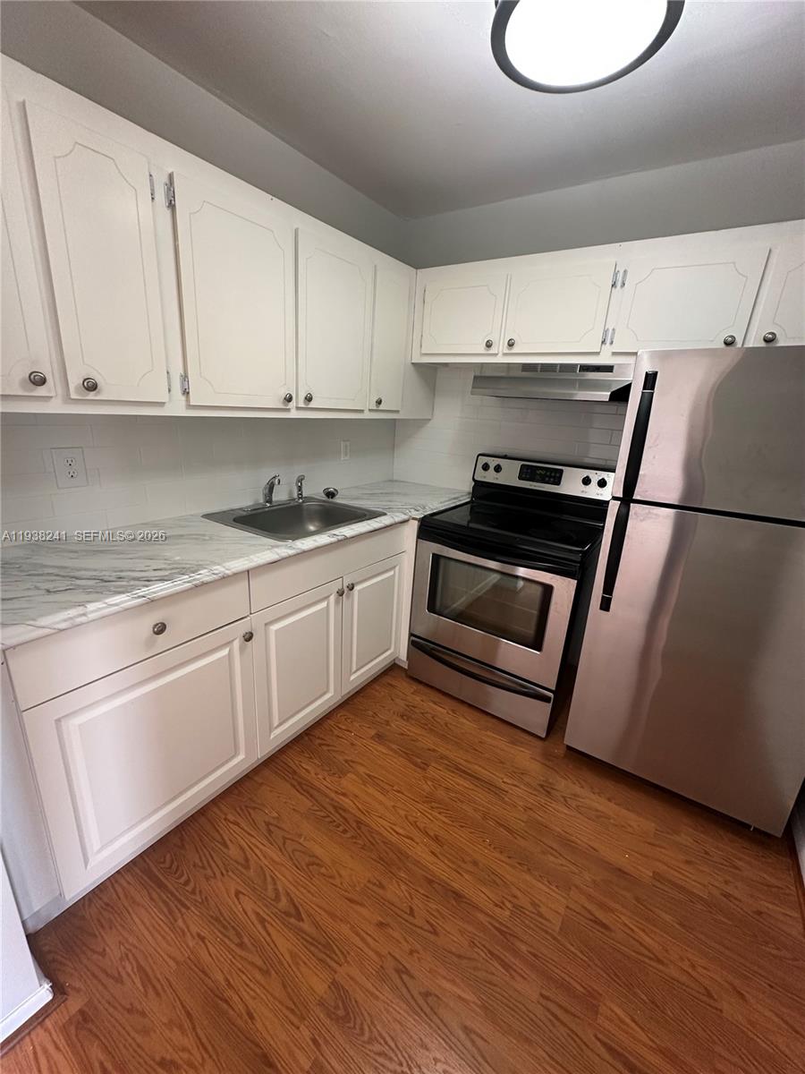 a kitchen with a sink a stove and cabinets