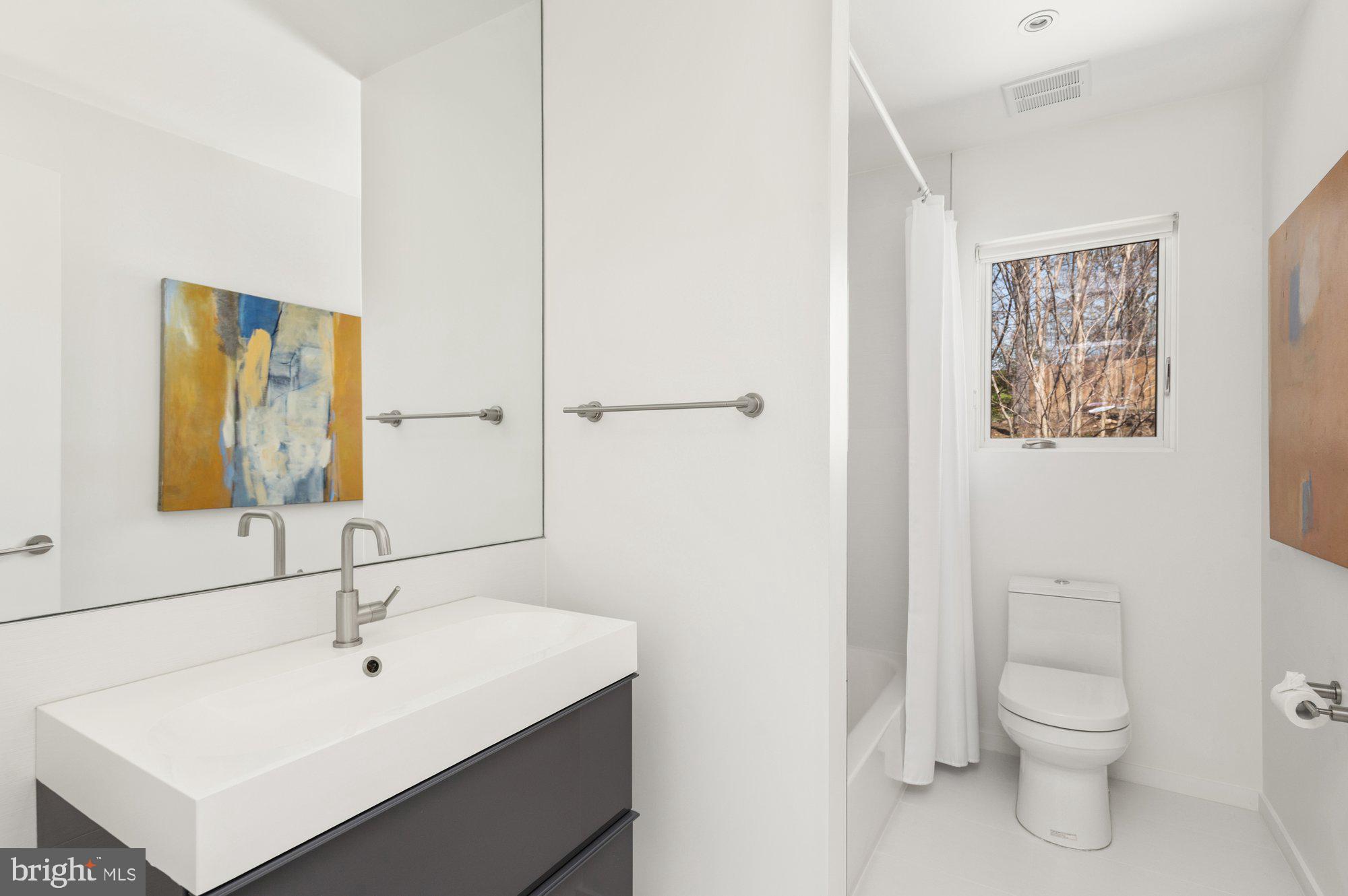 6016 Chesterbrook Road McLean, VA 22101 - Photo 40 of 67 a bathroom with a sink a toilet and mirror