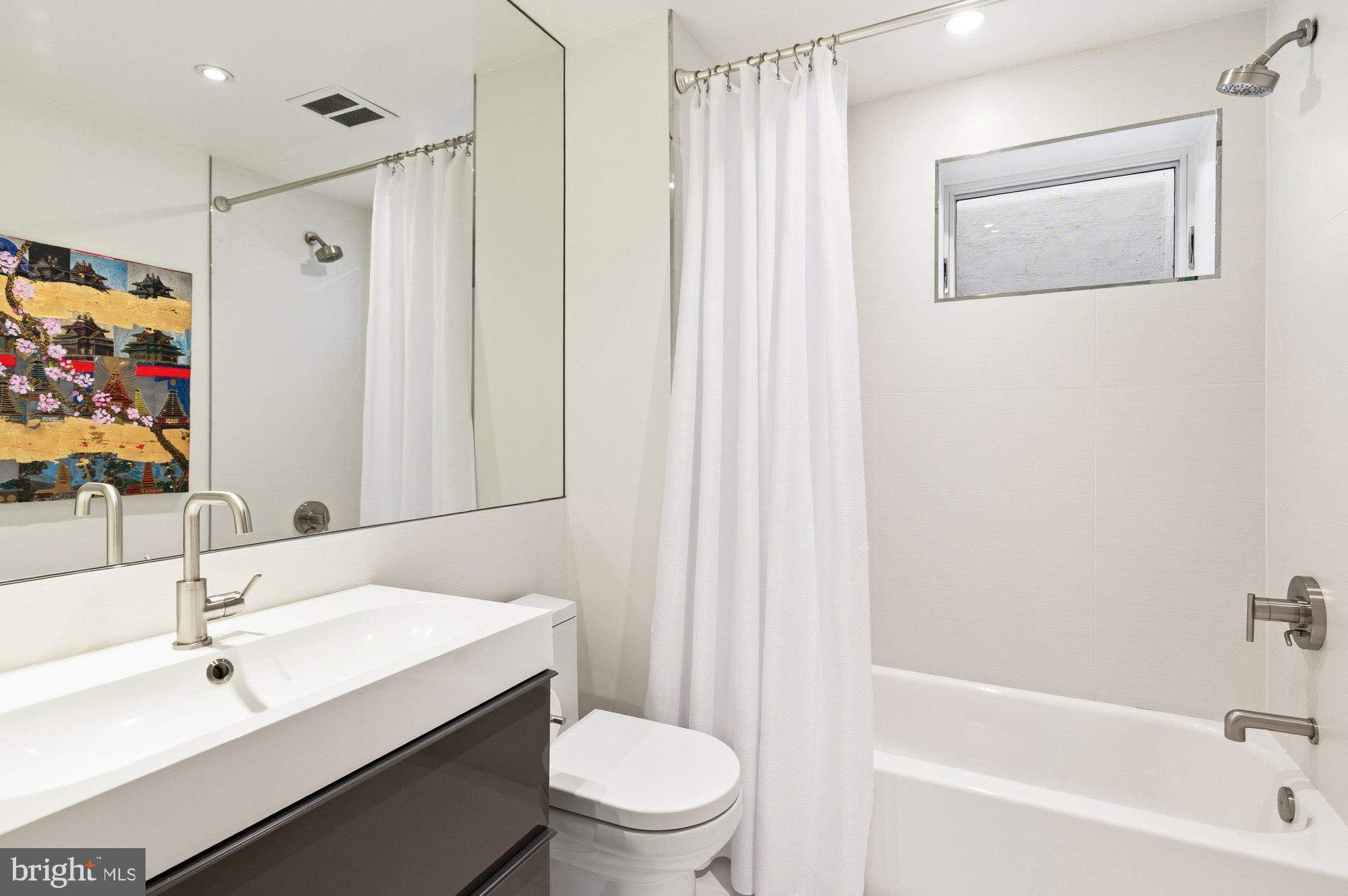 6016 Chesterbrook Road McLean, VA 22101 - Photo 50 of 67 a bathroom with a sink a toilet and shower curtain