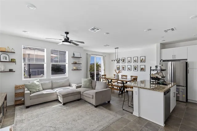 a living room with furniture kitchen view and a window
