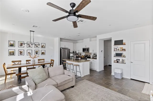 a living room with furniture kitchen view and a refrigerator
