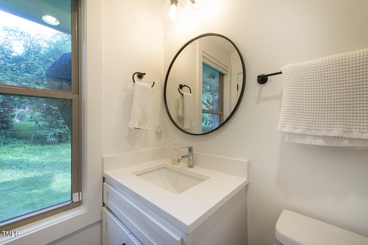 217 Lord Berkley Road Raleigh, NC 27610 - Photo 54 of 68 a bathroom with a sink a mirror and a toilet